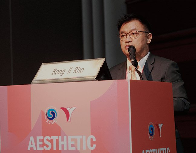 학회 연단에서 발표하는 의사, 연단에 학회 로고·'AESTHETIC'