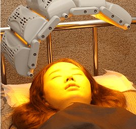 누운 여성 얼굴 위 LED 관리 장비
