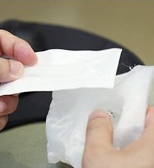 제작된 보형물 포장을 손으로 여는 모습